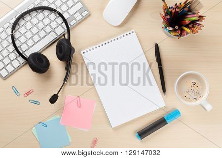 Office desk with headset, notepad and pc. Call center support table. Top veiw with copy space