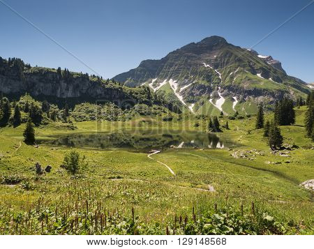 A view of Alpine mountains and the Koerbersee lake near the village Schroecken in Bregenzerwald region Vorarlberg Austria
