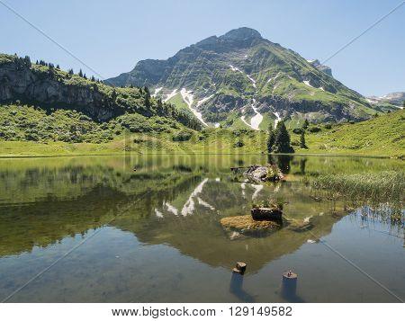 A view of Alpine mountains and the Koerbersee lake near the village Schroecken in Bregenzerwald region Vorarlberg Austria