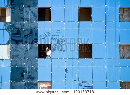Doha Qatar - April 10 2006: A worker in a window phoning in a costruction site of the business area