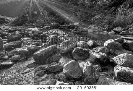 River water flowing through rocks at dawn sun light beams on the water beautiful Reshi River Sikkim India - black and white stock image of rivers in India