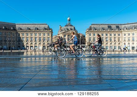 People Riding Bicycles In The Fountain In Bordeaux, France