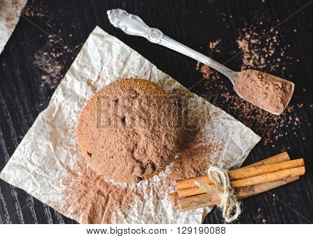 Chocolate muffins with cinnamon on dark background