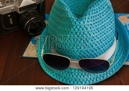 Preparation for traveltrip vacation tourism mock up of road map camerahat sunglasses on wooden table.