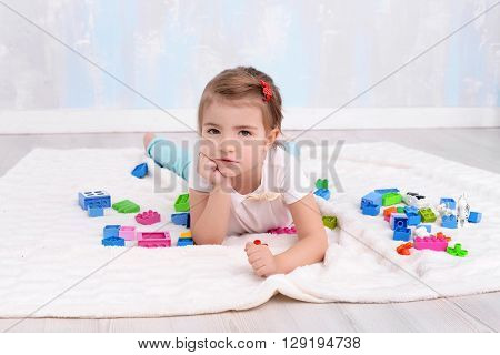 Pretty child girl playing with toys constructor
