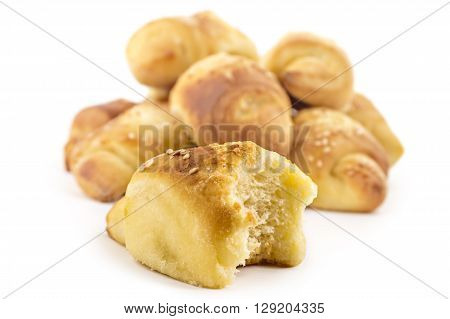 Fresh Serbian pastry rolls with cheese and sesame, kifla kiflice, one bitten, isolated on white background