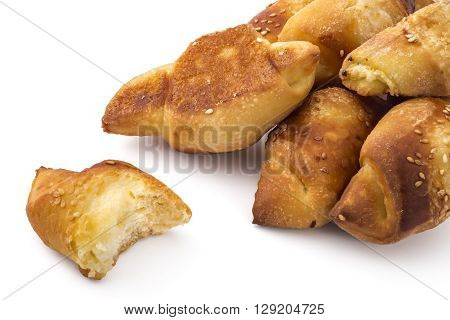 Fresh Serbian pastry rolls with cheese and sesame, kifla kiflice, one bitten, isolated on white background