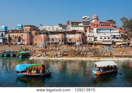 MADHYA PRADESH, INDIA - DEC 27, 2012: Two river boats floating on the river of historical asian city at sunny morning on December 27, 2012 in Chitracoot. Population of Chitrakoot is 22294 people.