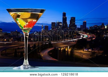 Martini glass with two dibs inside against the view of city skyline