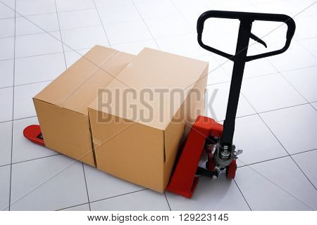 Manual pallet truck with carton boxes indoors