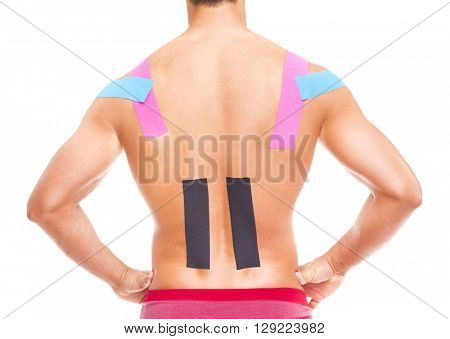 Muscular man with kinesiotaping on the back and shoulders, isolated on white background