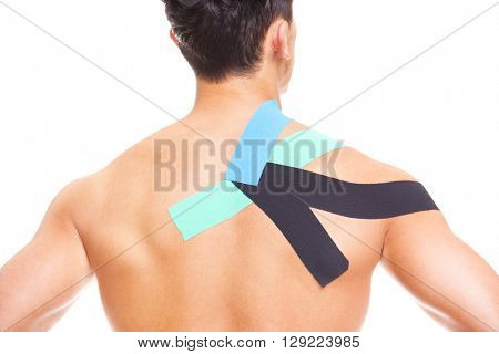 Muscular man with kinesiotaping on the shoulder, isolated on white background