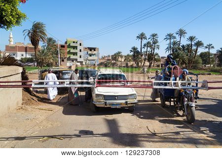 DARAW, EGYPT - FEBRUARY 6, 2016: Vehicles waiting in line at train crossing.