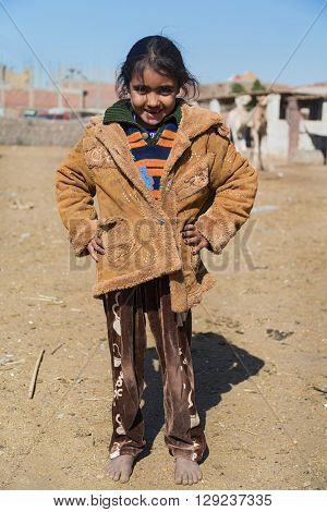 DARAW, EGYPT - FEBRUARY 6, 2016: Portrait of bare feet local girl posing for camera.