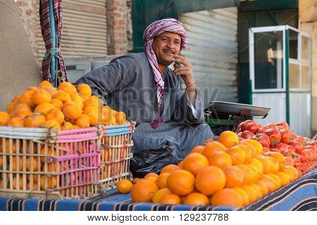 DARAW, EGYPT - FEBRUARY 6, 2016: Local food vendor at Daraw market selling oranges and tomatoes.