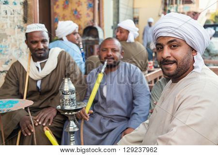 DARAW, EGYPT - FEBRUARY 6, 2016: Local men smoking shisha pipe at Daraw market.