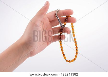 Hand holding a tespih on a white background