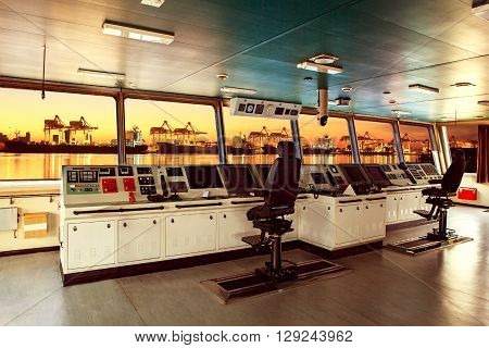wheelhouse control board of modern industry ship approaching to harbor at night