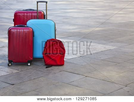 Luggage consisting of three large suitcases and travel backpack on the street. Holiday and travel concept