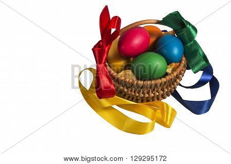 Isolated Easter Wicker basket with pink vines painted chicken eggs on a white background decorated with colorful ribbons.