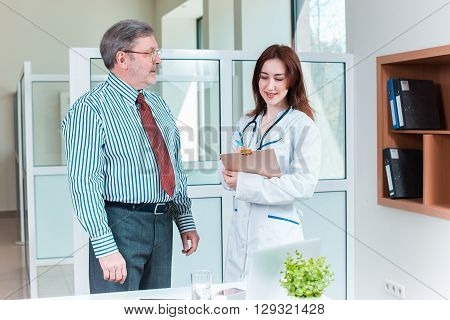 patient smiling to his doctor in medical office. Healthcare concept