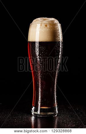 Beer Glass With Drops On Black. Fresh! Much Foam! Beer Bubbles Closeup. Draft. Overflow Beer Glass.