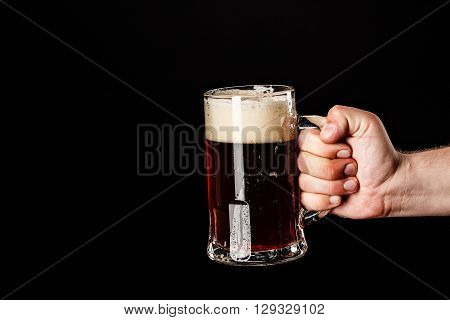 Man Hand With Beer Glass With Drops On Black. Fresh! Much Foam! Beer Bubbles Closeup. Draft. Overflo