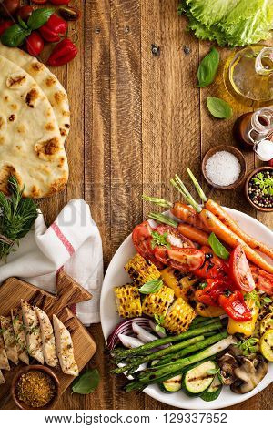 Grilled vegetables and chicken on wooden table overhead shot