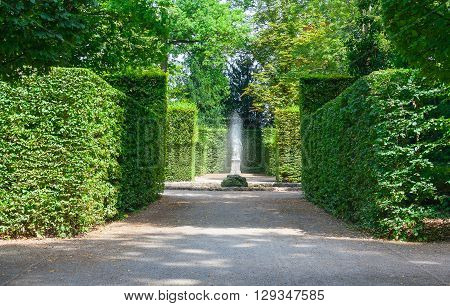 Beautiful garden with green hedges with a fountain and walkways.