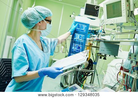 Surgery assistant perfusionist operating a modern heart lung machine