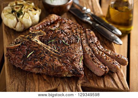 Tbone beef steak cooked on a grill with rosemary and garlic