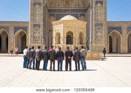 Buckara Uzbekistan - Aprilr 16 2014: Local people in the inside square of the Kalon mosque