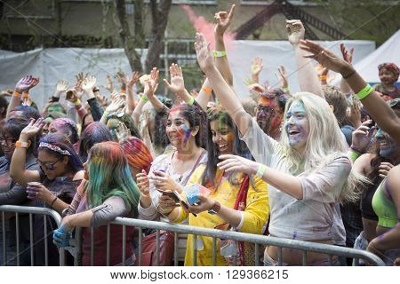 NEW YORK - APR 30 2016: A large crowd with colorful powder on their faces celebrate Holi Hai Festival of Colors and watch performers on the stage hosted by NYC Bhangra in New York on April 30 2016.