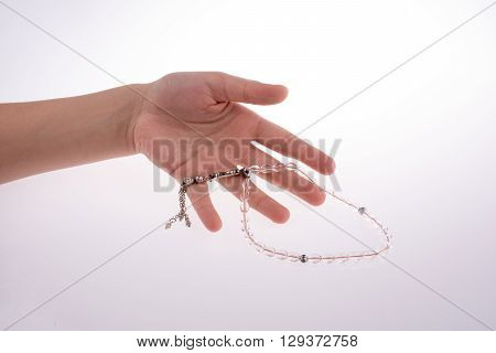 Hand holding a tespih on a white background