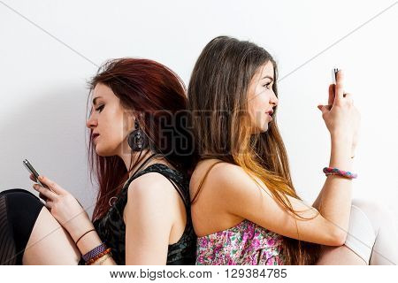 New Solitude Is When Two Women Are Together And Ignore Each Other While Watching At Their Mobile Pho