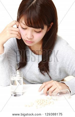 portrait of young Japanese woman suffers from melancholy on white background