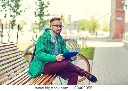 people, style, technology and lifestyle - happy young hipster man with tablet pc computer and fixie bike sitting on bench in city
