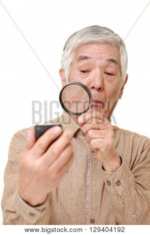 senior Japanese man with presbyopia on white background