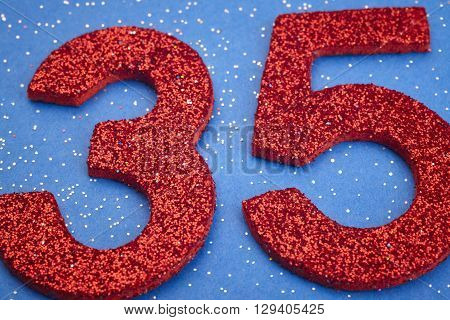Number thirtyfive red color over a blue background. Anniversary. Horizontal