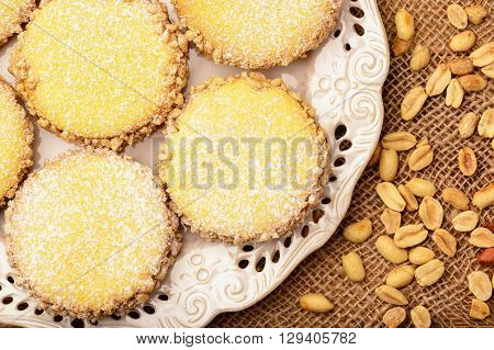 Butter cookies (alfajores) with caramel and peanut on wooden background.