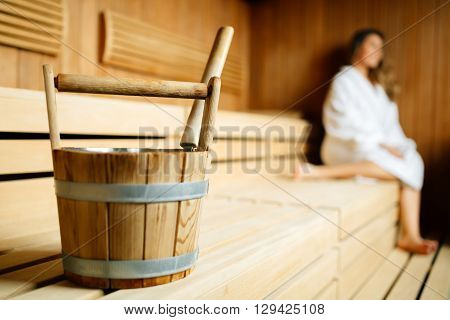 Beautiful woman sitting in finnish sauna and sweating