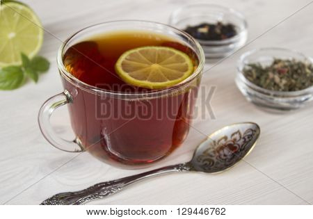 Hot tea in a cup with different sort of dried tea