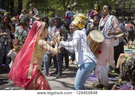 NEW YORK - APR 30 2016: A female member of NYC Bhangra and a spectator dance together in the crowd at the Holi Hai Festival of Colors in Dag Hammerskjold Plaza in New York April 30, 2016.