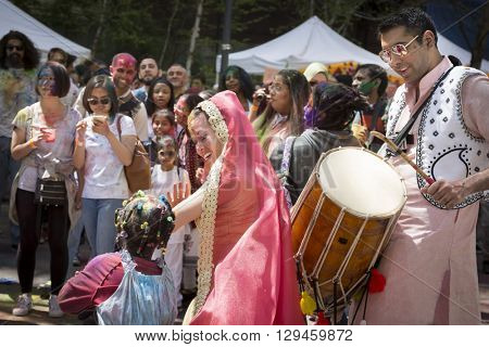 NEW YORK - APR 30 2016: A female member from NYC Bhangra dances with a little girl in the crowd at the Holi Hai Festival of Colors in Dag Hammerskjold Plaza in New York April 30, 2016.