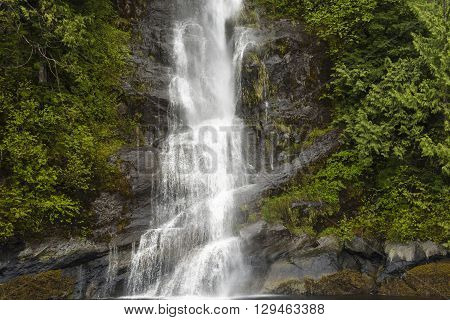A waterfall falling down the side of a mountain in the rain forest