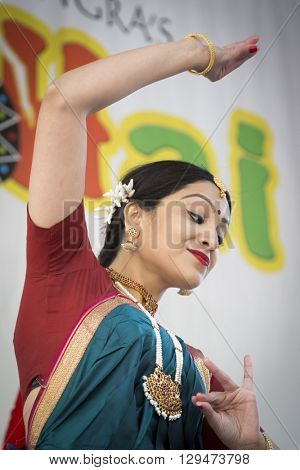 NEW YORK - APR 30 2016: A female dancer from NYC Bhangra uses the katakamukha mudra, a hand gesture, while performing on stage at the Holi Hai Festival of Colors in New York on April 30 2016.