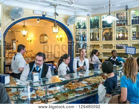 Belem Portugal - April 28 2014: A group of tourists buying the famous Pasteis de Belem (Pastries of Belem). The pastries of this shop are well known around the world and a touristic destination in Belem Portugal.