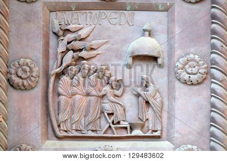 PISA, ITALY - JUNE 06, 2015: Washing of the Feet on the San Ranieri gate of the Cathedral St. Mary of the Assumption in Pisa, Italy on June 06, 2015