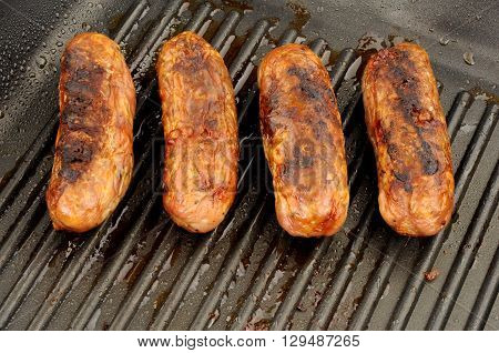 Freshly cooked pork sausages in a non stick griddle frying pan