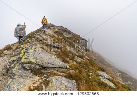 Hiking Trail with Tourists on the Hill in the Mountains in the Mist
